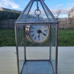 Table clock in a glass lantern.