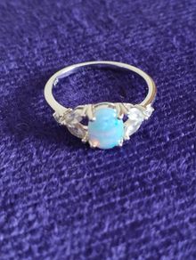 Ring made of 925 silver with oval opal of blue shade and cubic zirconia.