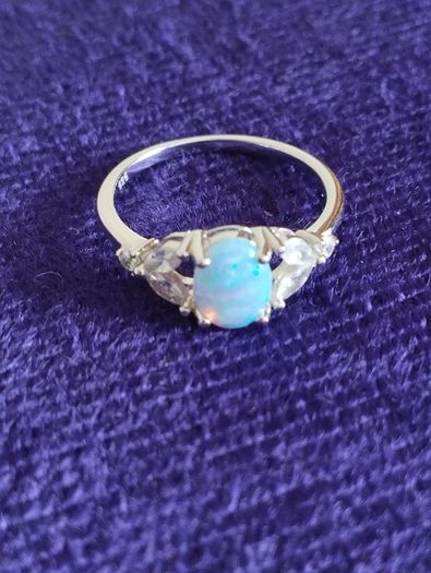 Ring made of 925 silver with oval opal of blue shade and cubic zirconia.
