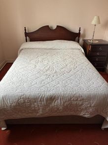 Double bed with wooden headboard and matching locker