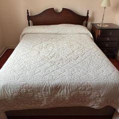 Double bed with wooden headboard and matching locker
