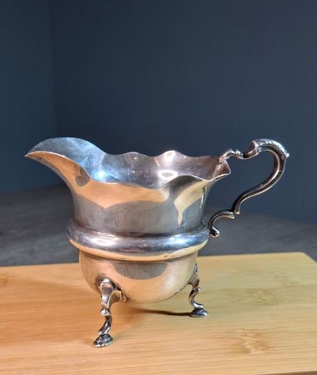 Antique silver cream jug with scalloped rim