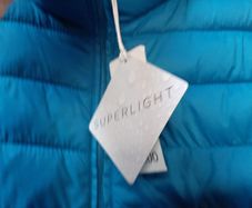New blue jacket with hood and new baseball cap tag attached