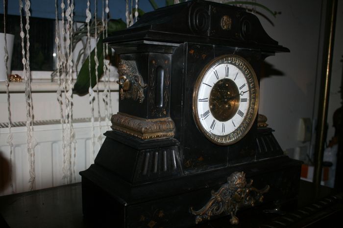 Victorian French Black Slate Mantle Clock (Very large and heavy) with bronze ornamentation Oversized. Open escarpment slate plate Roman numerals. Circa 1890s. Accented with Trojan head. Flanked by two Hellenistic ladies heads on sides. Rose cartouche mask