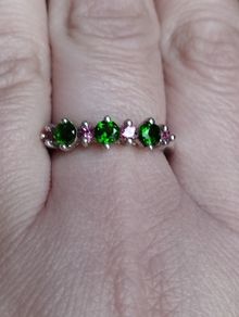 A 925 sterling silver ring with green and pink stones.