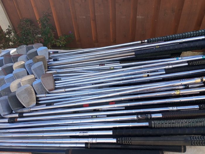 A selection of golf clubs and bags. All right handed clubs.