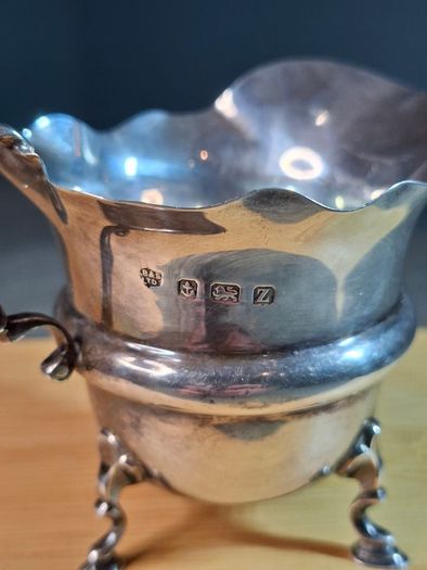 Antique silver cream jug with scalloped rim