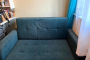Grey fabric sofa bed with large storage compartment.