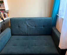 Grey fabric sofa bed with large storage compartment.