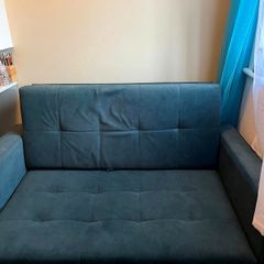 Grey fabric sofa bed with large storage compartment.