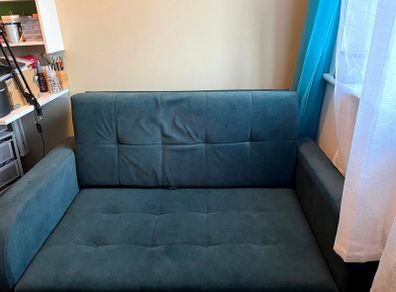 Grey fabric sofa bed with large storage compartment.