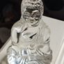 A glass Buddha figurine seated in the lotus position. Image 2