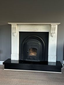 Marble fireplace surround and plinth with solid fuel stove