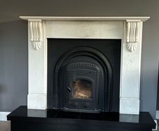 Marble fireplace surround and plinth with solid fuel stove