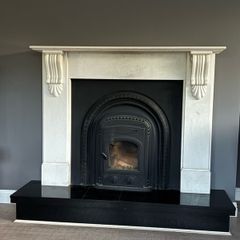 Marble fireplace surround and plinth with solid fuel stove