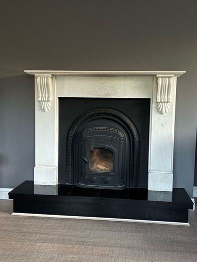 Marble fireplace surround and plinth with solid fuel stove