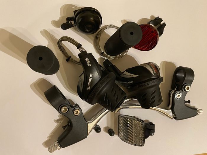 New Shimano Gear Shifters RevoShift SL-RS36-7-LN Twist Grip Shifter for 3 x 7 Speed Mountain bike Includes Gear Cables, Set Black Grips, Aluminium Brake lever, Set Light Reflector, Set Valve Caps and Flick-bell.