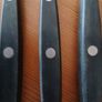 A 12-piece stainless steel steak knife and fork set with wooden riveted handles. Image 9