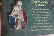A vintage green marble wall plaque with a metal sculpture of the Holy Family.