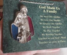 A vintage green marble wall plaque with a metal sculpture of the Holy Family.