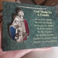 A vintage green marble wall plaque with a metal sculpture of the Holy Family.