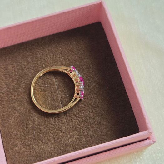 Beautiful yellow gold ring featuring three stunning rubies surrounded by sparkling cubic zirconia stones. Size M, in beautiful condition.