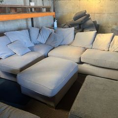 Grey corner sofa with scatter cushions and footstool