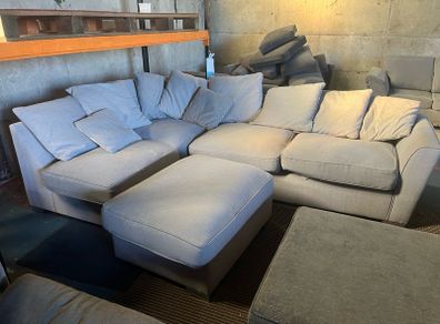 Grey corner sofa with scatter cushions and footstool