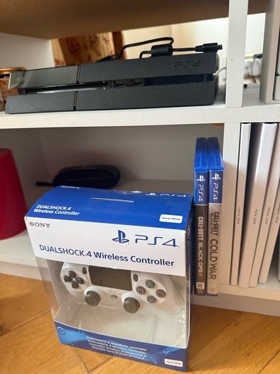 PS4 console with dual shock 4 controller and two COD games