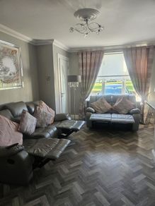 Grey leather recliner sofa set with pink curtains