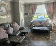 Grey leather recliner sofa set with pink curtains