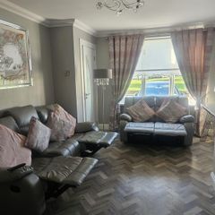 Grey leather recliner sofa set with pink curtains