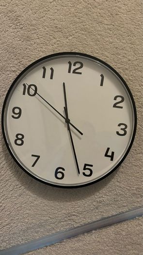 2 wooden chairs and a wall clock