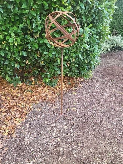 Corten steel garden sphere on a stem