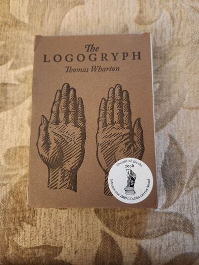 The Logogryph. By Thomas Wharton. First Edition Complete With Presentation Sleeve Paperback In Very Good Condition. 37