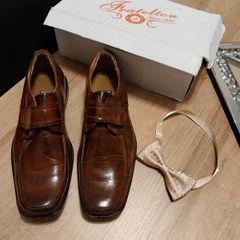 As new in box size 4 brown leather with bow tie also