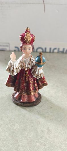 Infant of Prague devotional figurine featuring ornate red and gold robes and a matching crown.