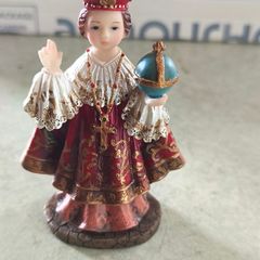 Infant of Prague devotional figurine featuring ornate red and gold robes and a matching crown.