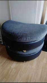 Grey crescent-shaped footstool with detachable top