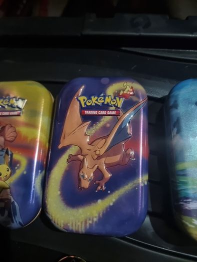 Three Pokemon tins with two coins.