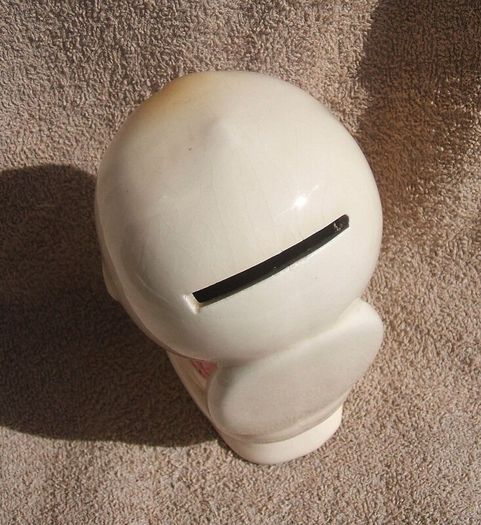 A vintage novelty money box in form of a young child sitting on a toilet (1930s to 1960s)