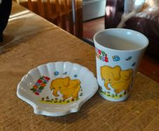 vintage ceramic cup and matching shell-shaped dish set featuring  cartoon yellow elephant "Sunny Funnies"