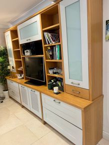 large wooden entertainment center or wall unit featuring a mix of open shelving, glass fronted cabinets, and lower drawers