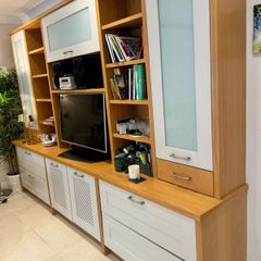 large wooden entertainment center or wall unit featuring a mix of open shelving, glass fronted cabinets, and lower drawers
