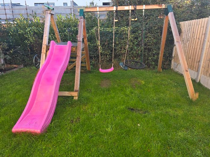 Wooden climbing frame with slide and swings