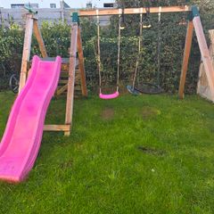 Wooden climbing frame with slide and swings