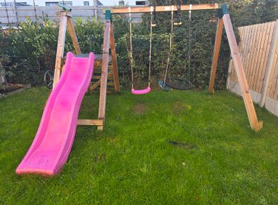 Wooden climbing frame with slide and swings