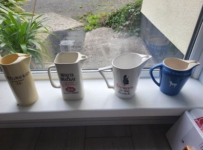 Four whisky advertising water jugs