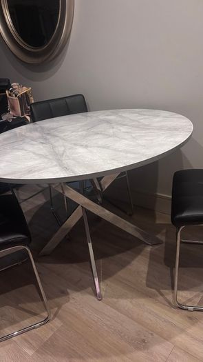 Round marble-effect dining table with 4 black chairs