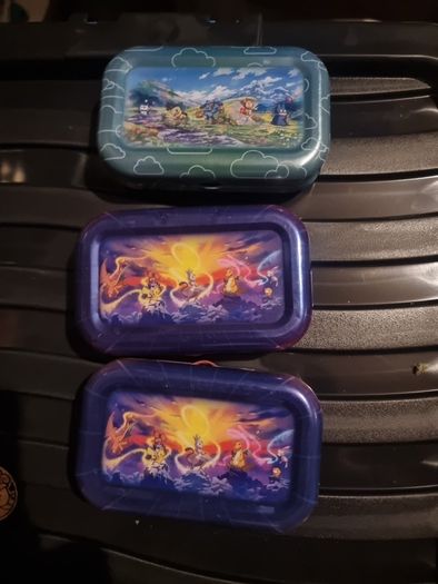 Three Pokemon tins with two coins.